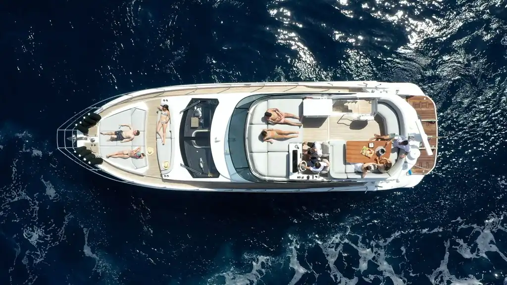 Vista aérea del yate Azimut 53 con pasajeros tomando el sol y comiendo en cubierta