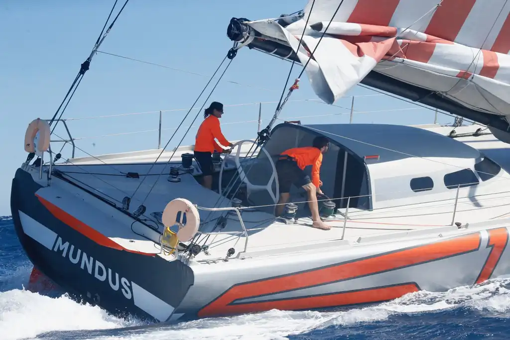 Tripulantes gobernando el timón del velero Mundus durante la navegación